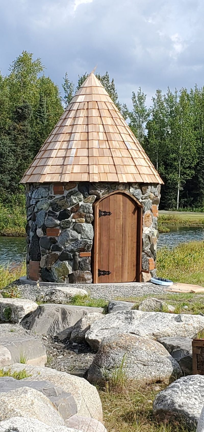 A stone cottage with a cedar-shingle roof among the boulders