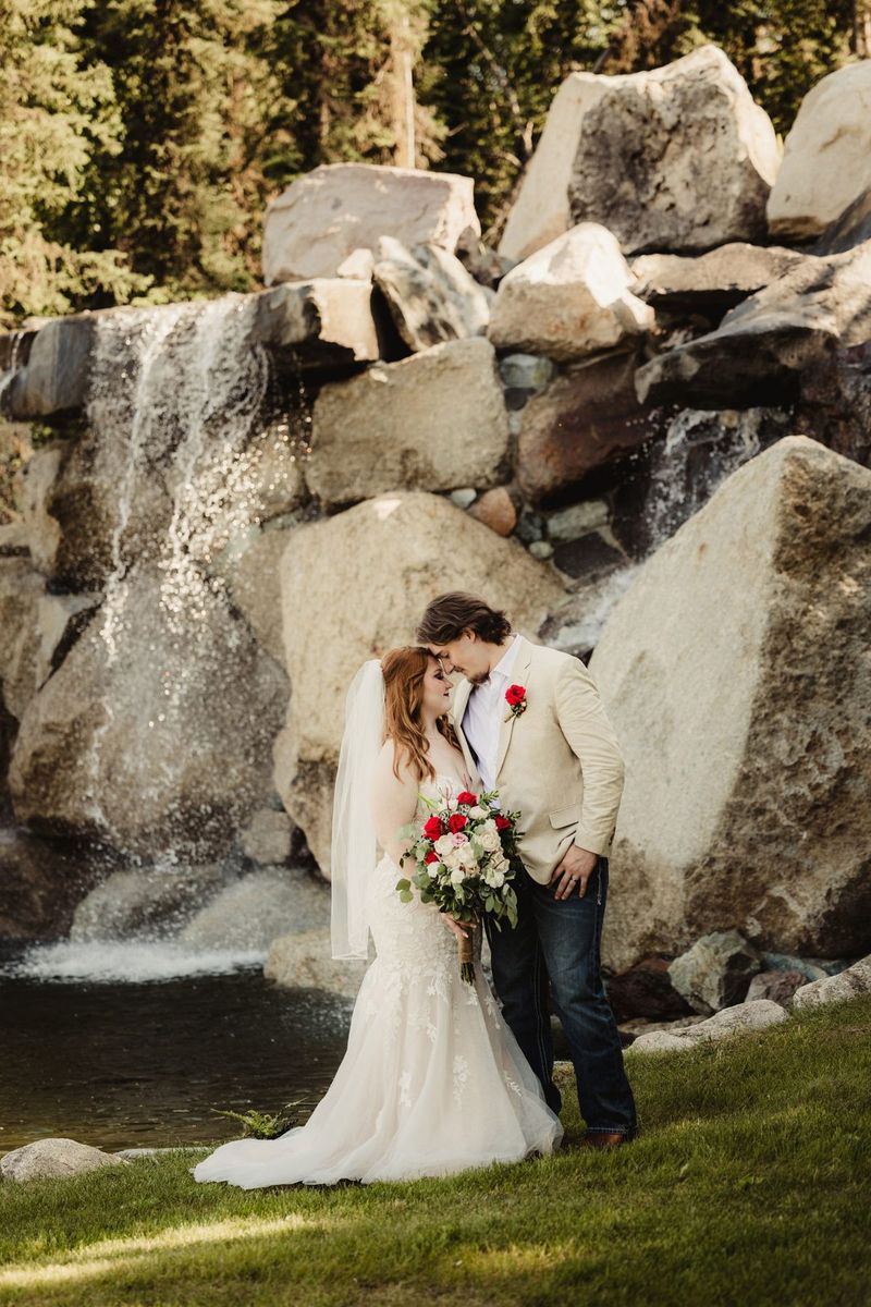 A couple kissing in front of the waterfall