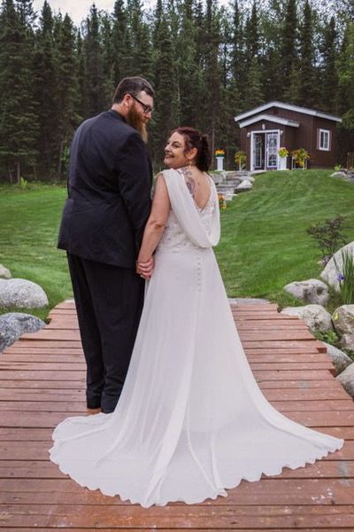 A bride and groom on the boardwalk looking toward the she-shed