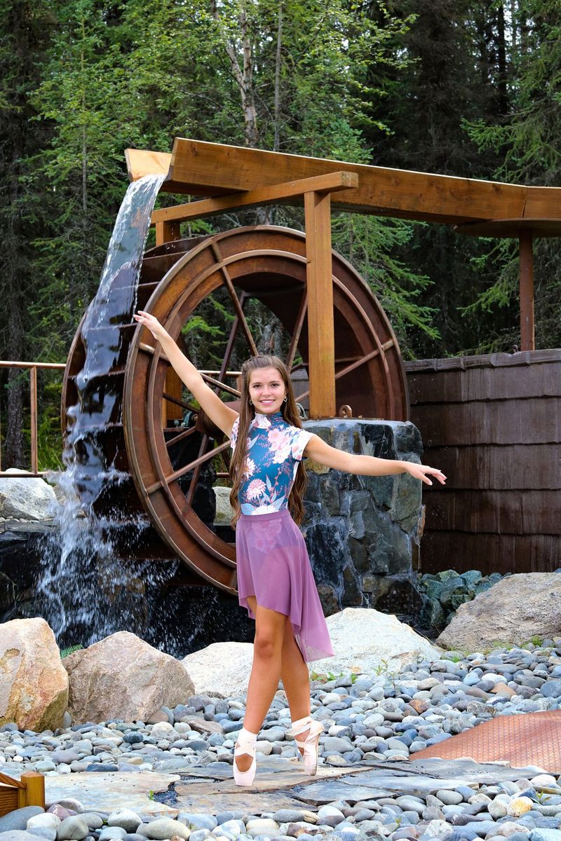 A ballet dancer en pointe in front of the waterwheel