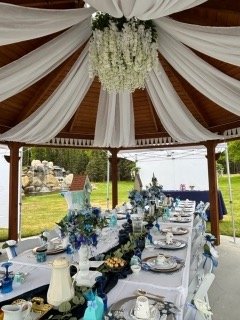 The gazebo draped in white fabric over a long banquet table