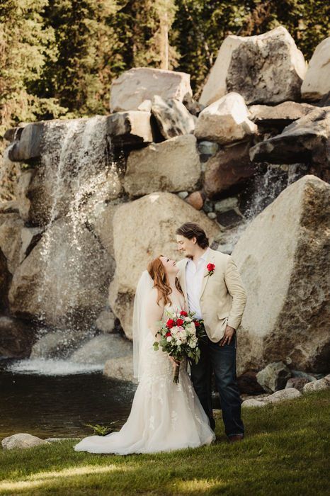 A bride and groom in front of the waterfall